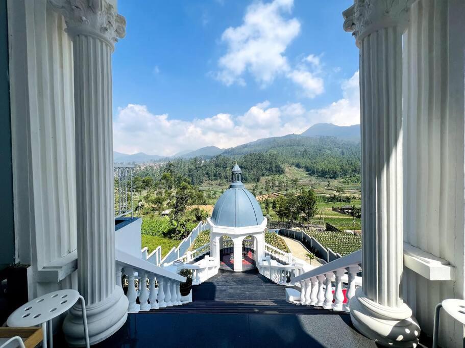 a view from the balcony of a building with columns at Skyline BlueDome Villa Ciwidey in Ciwidey