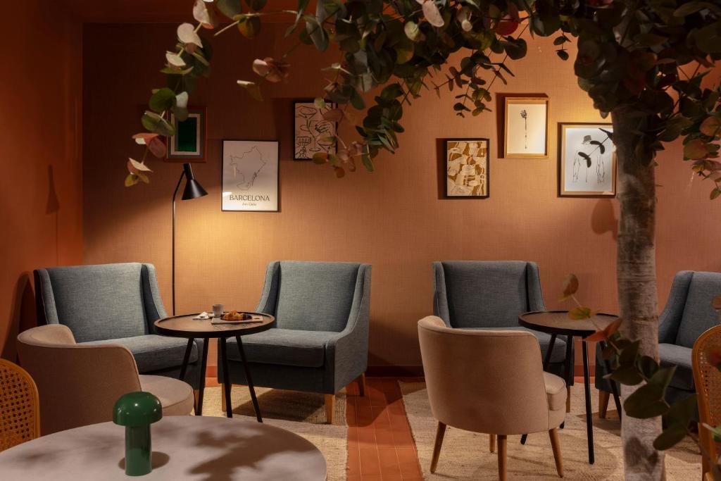 a waiting room with chairs and tables and a tree at TOC Hotel Las Ramblas in Barcelona