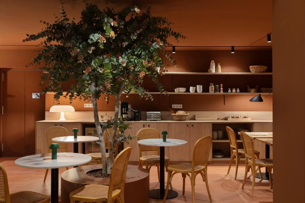 a restaurant with tables and chairs and a tree at TOC Hotel Las Ramblas in Barcelona
