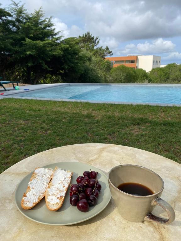een bord brood en druiven en een kopje koffie bij House of green leaves in Chelreira