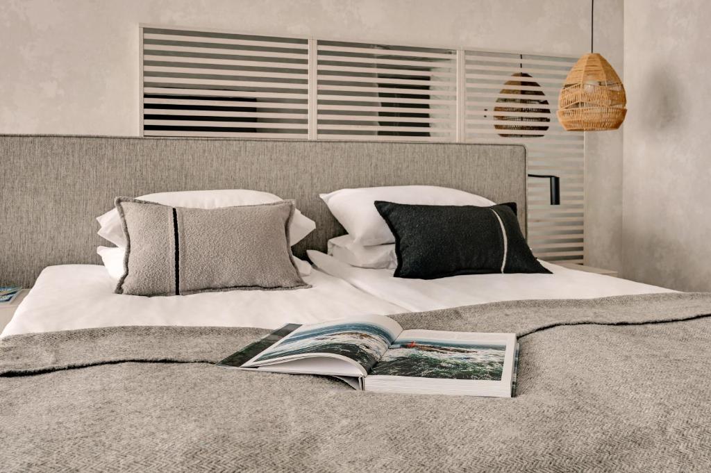 a bedroom with a bed with a book on it at GRANO HOTEL Solmarina in Wiślinka