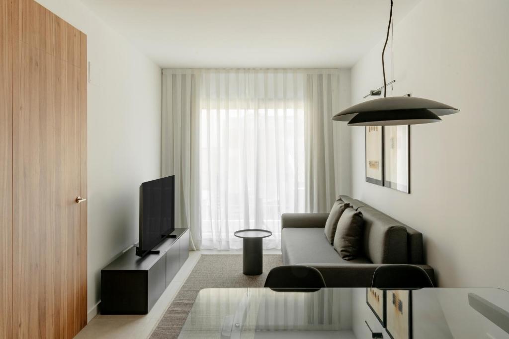 a living room with a couch and a television at Europa Apartments in Hospitalet de Llobregat