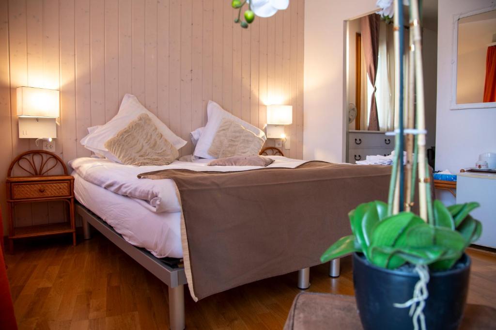 a bed with pillows on it in a room at Hotel de la Place in Vevey