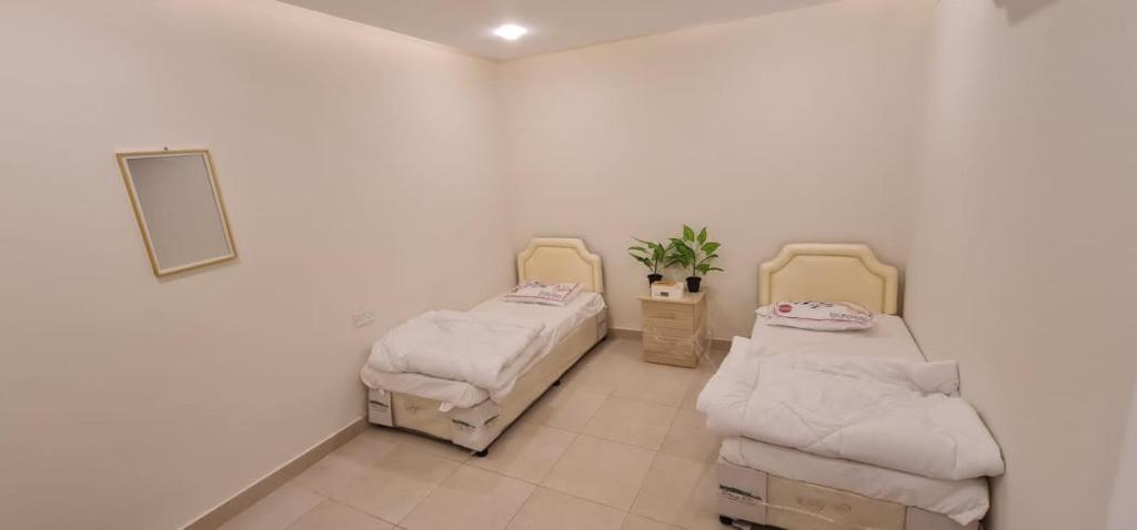 a room with two beds and a mirror at شقة فندقية مستقلة in Daḩārīz