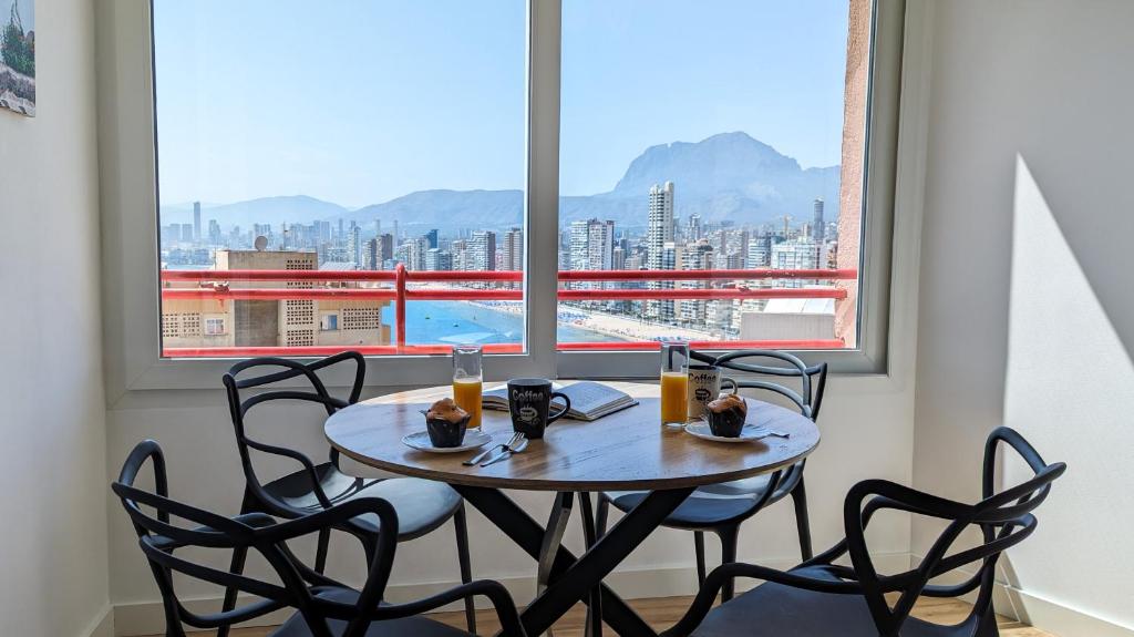 a table and chairs in a room with a large window at DON MIGUEL sea view apartment in Benidorm