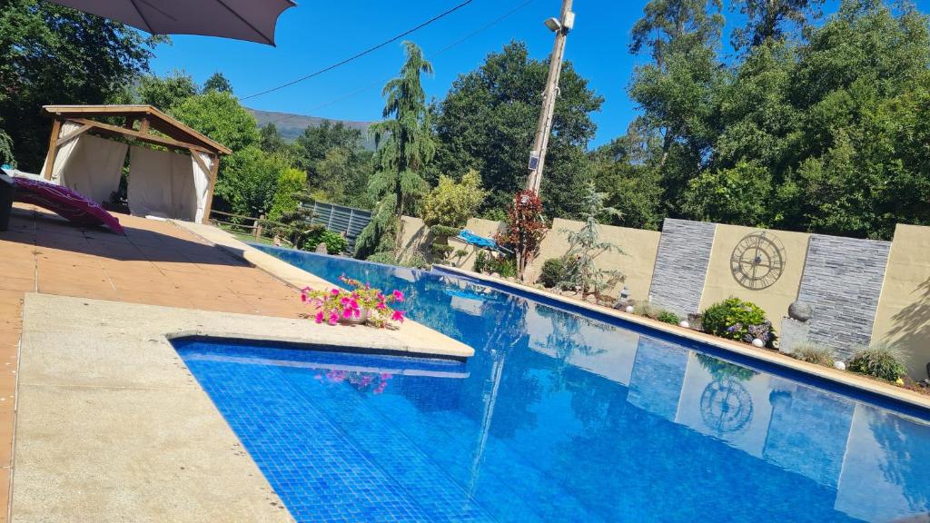 a swimming pool with a fountain in the middle at Casita Sarabia in Ponteareas