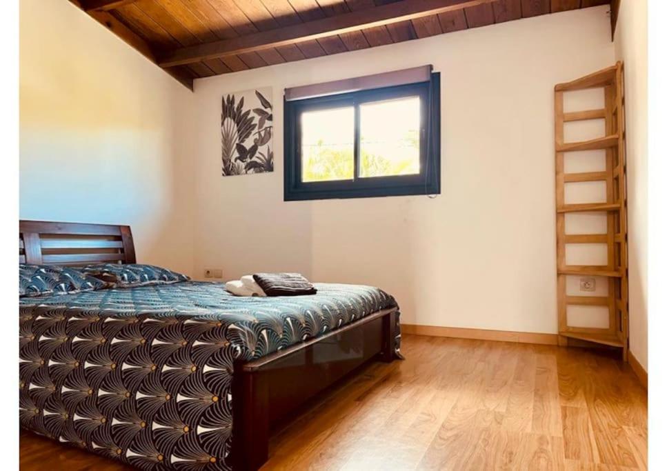 ein Schlafzimmer mit einem Bett in einem Zimmer mit einem Fenster in der Unterkunft La flibuste entre lagon & volcan in Saint-Pierre