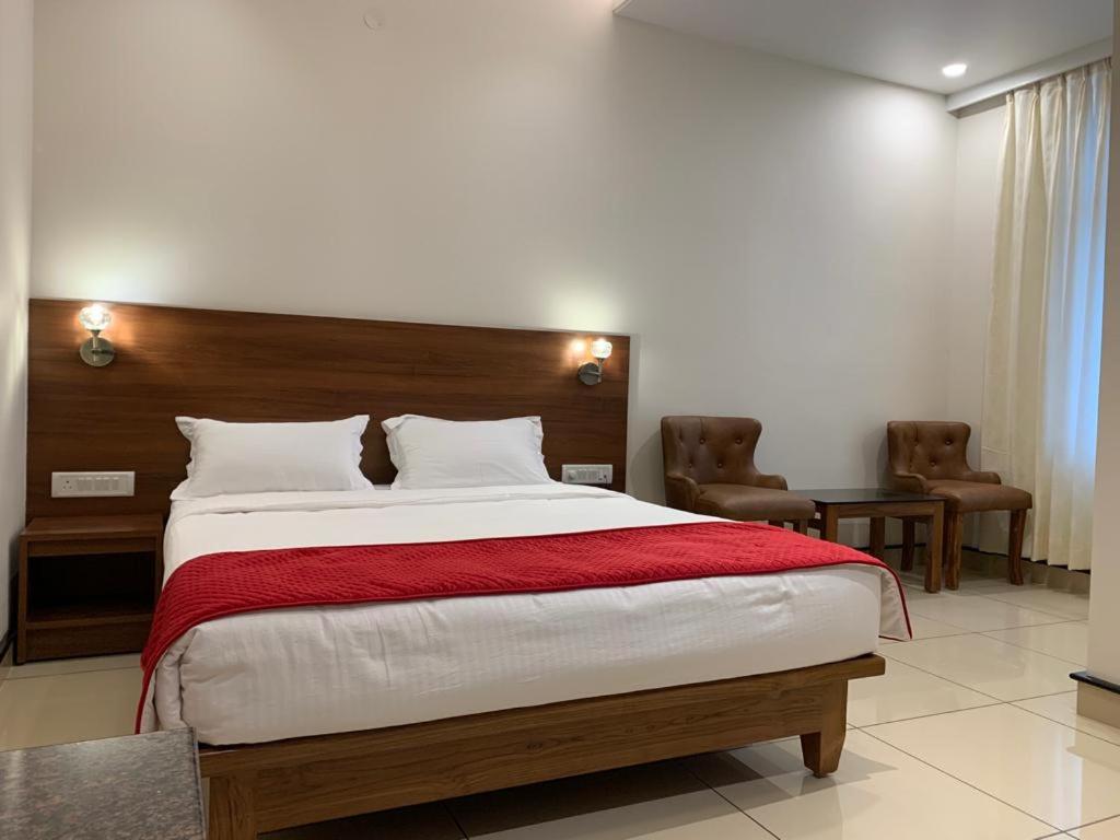 a bedroom with a large bed with a red blanket at JESTA RESIDENCY in Hassan