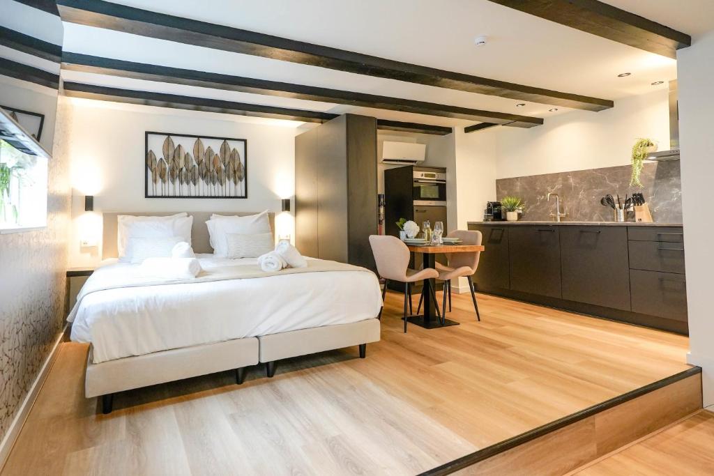 sypialnia z dużym białym łóżkiem i kuchnią w obiekcie Luxury City Center Studio w mieście Delft