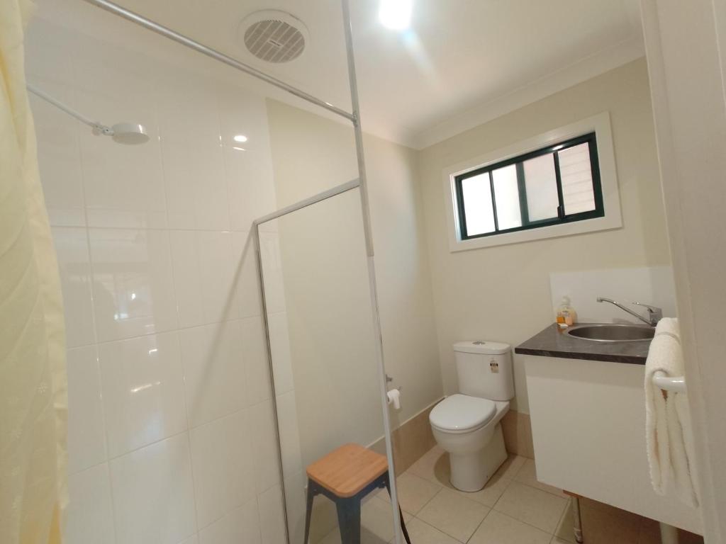 y baño con ducha, aseo y lavamanos. en T's Resort & Motel, en Port Macquarie
