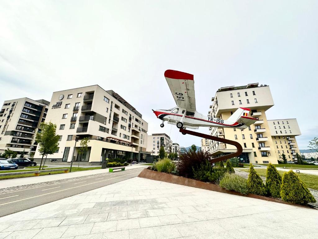 a model of a plane on a rail in front of buildings at Kasper Coresi Mall - Rise Private Apartments & Suites in Braşov