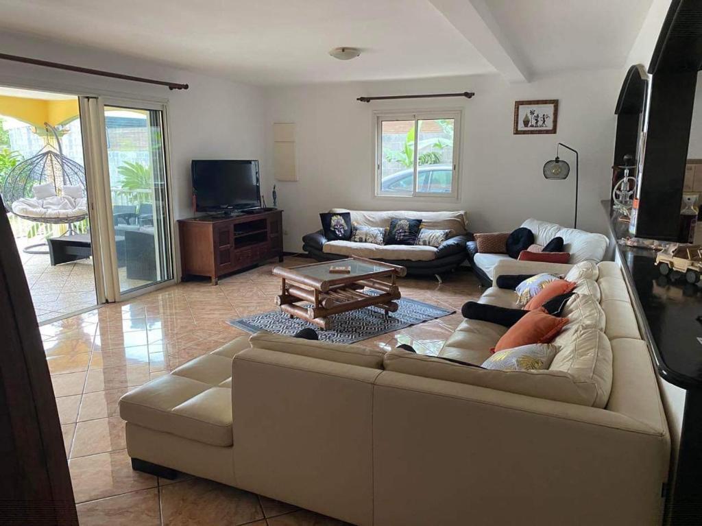 a living room with a couch and a tv at Villa Dakar in Saint-Pierre