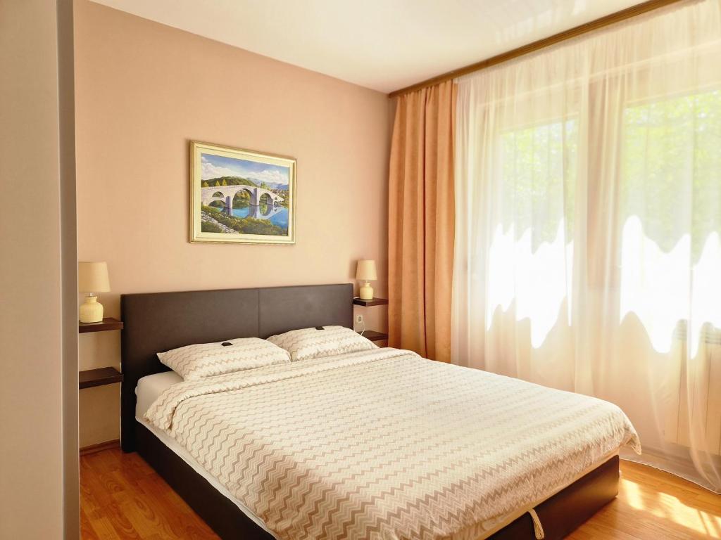 a bedroom with a large bed and a window at Spago Apartment in Konjic