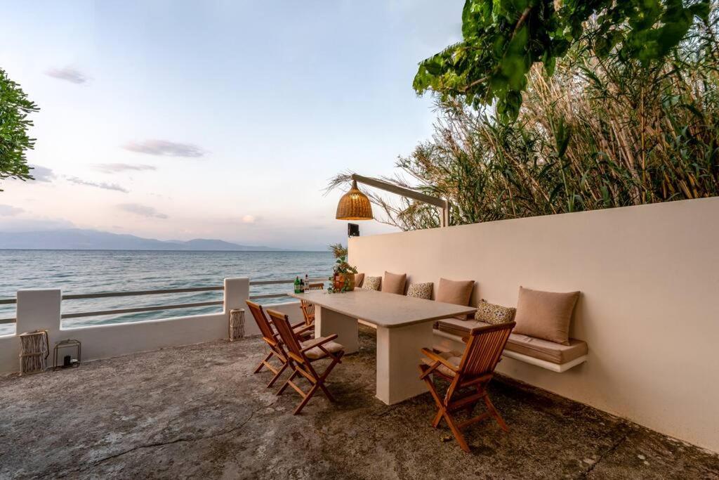 Ein Tisch und Stühle auf einer Terrasse mit Blick auf das Meer in der Unterkunft Evoque place in Egio