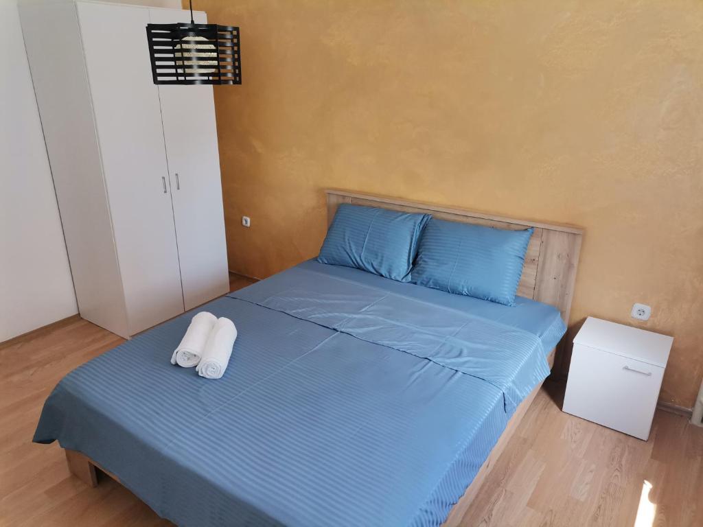 sypialnia z niebieskim łóżkiem i 2 ręcznikami w obiekcie CALLA 5 Apartment - Main Square, in the City Shopping Center - PARKING SLOT WITH SECURITY AND VIDEO CAMERA w mieście Skopje