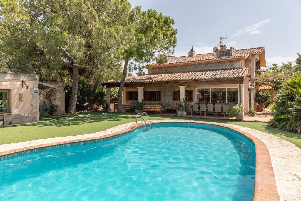 a swimming pool in front of a house at Villa Marjals in Muro