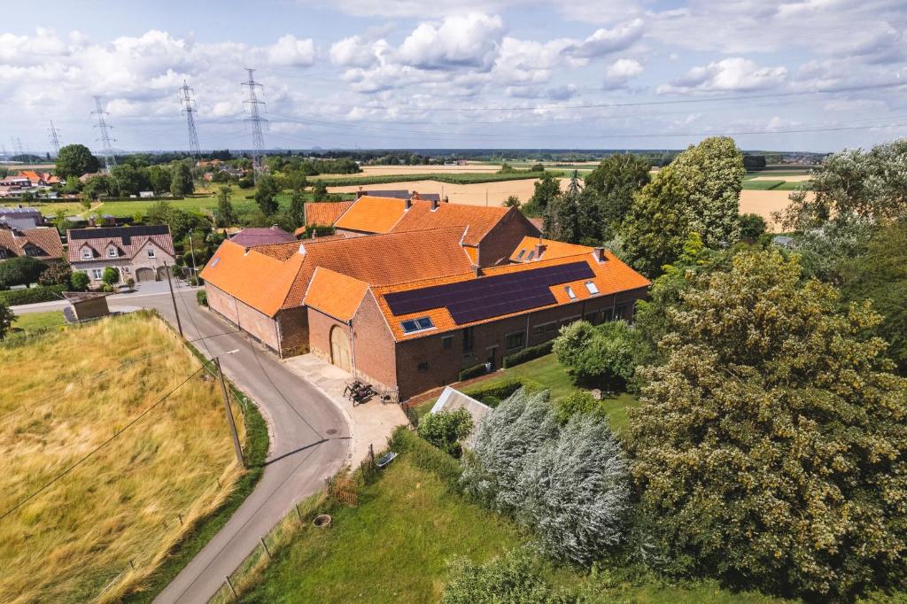 een uitzicht op een groot bakstenen gebouw met oranje daken bij Vakantiewoning & Fietslogies V E L O, Tussen Hasselt en Maastricht in Bilzen