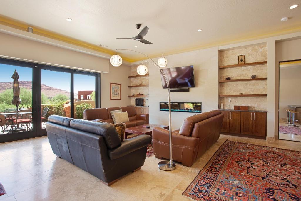 a living room with leather furniture and a flat screen tv at Red Rock Escape with Suite in St. George