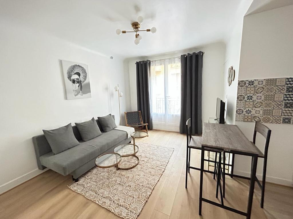 een woonkamer met een bank en een tafel bij Paris cosy studio near Beaugrenelle and Eiffel Tower in Parijs