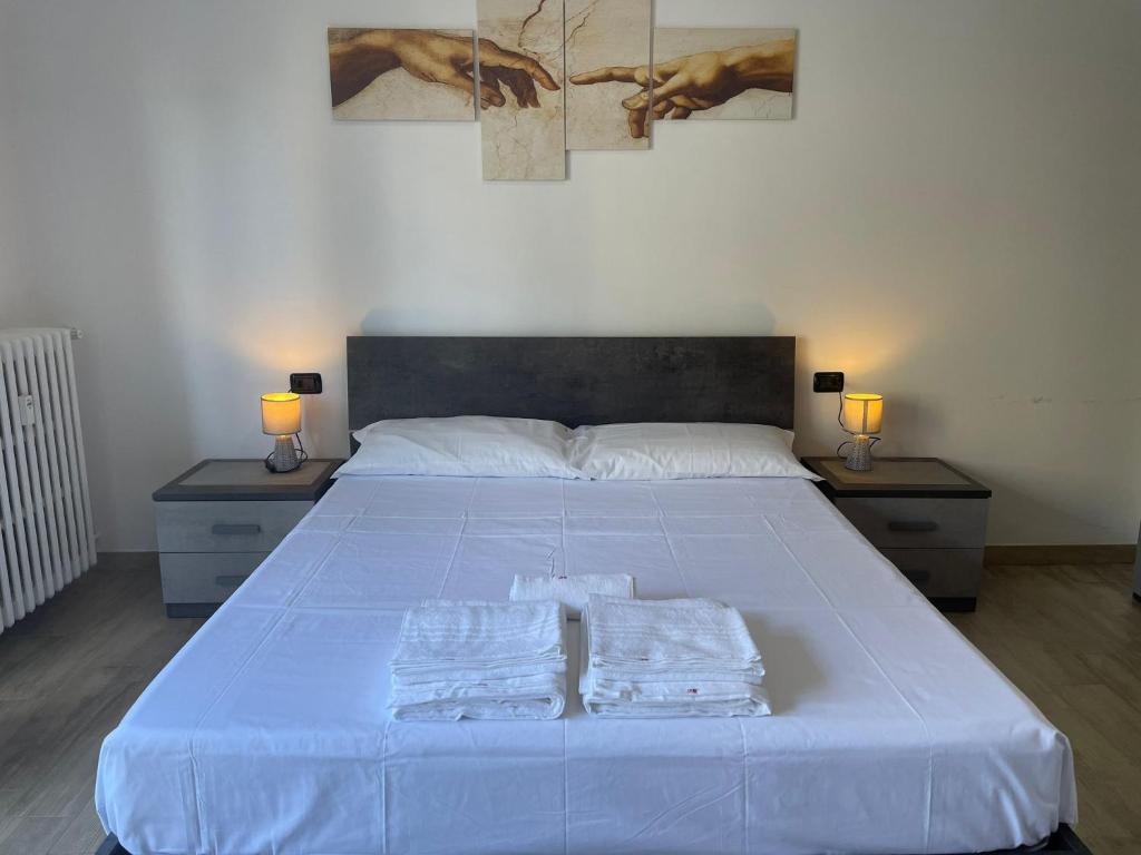 um quarto com uma cama grande com duas toalhas em Accogliente Loft ben servito em Novara