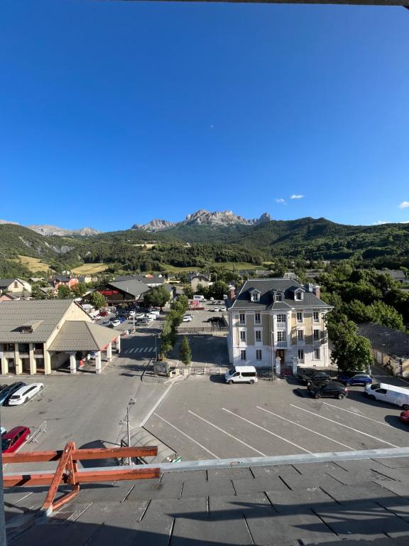 ariale Aussicht auf einen Parkplatz mit einem Gebäude in der Unterkunft Le Bellevue in Barcelonnette