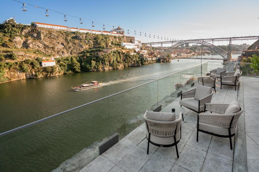 a row of chairs sitting next to a river at Eurostars Porto Douro in Porto