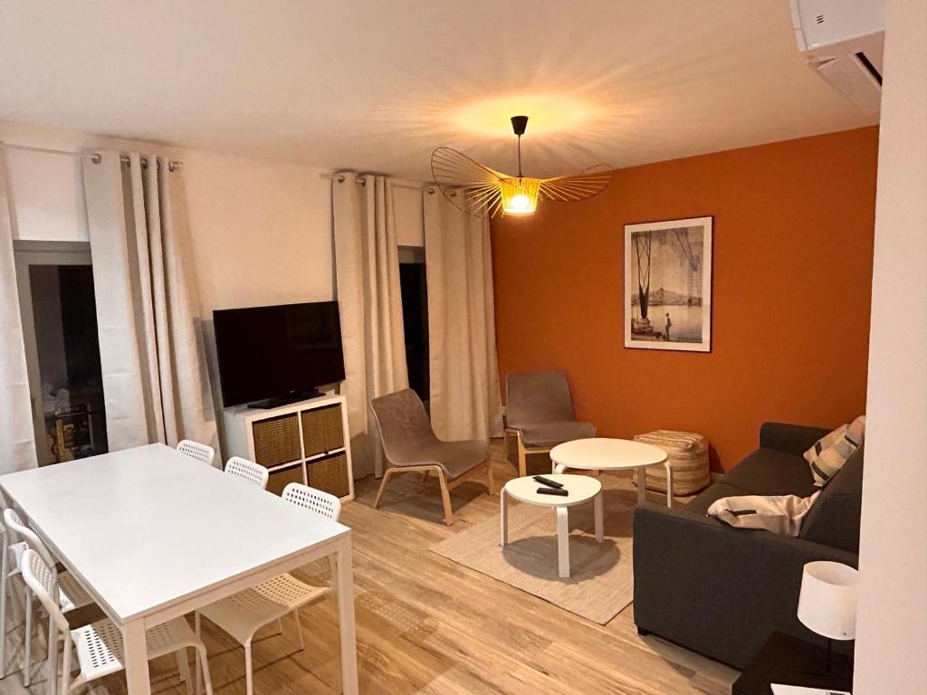 ein Wohnzimmer mit einem Sofa und einem Tisch in der Unterkunft Bel appartement climatisé 2 chambres à 20m du Vieux-Port in Marseille
