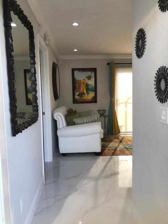 a living room with a white couch and a mirror at The Havens hideaway in Freeport