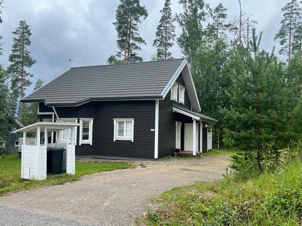 uma casa a preto e branco com uma entrada em Riihipeikko Jyväskylän läheisyydessä Muuramen Riihivuoressa em Muurame
