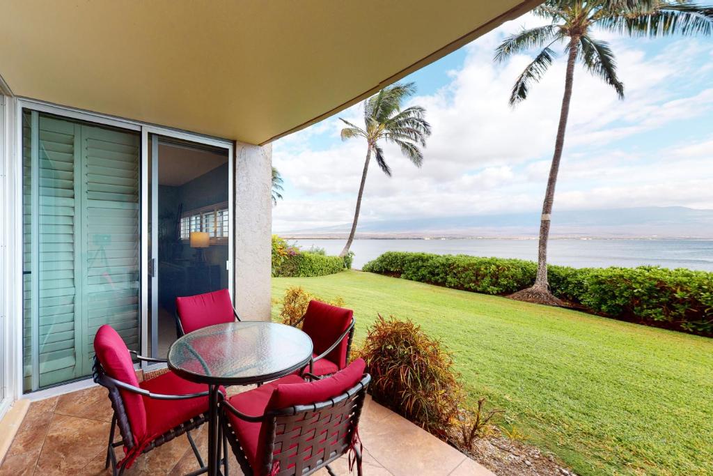 a patio with a table and chairs and a view of the ocean at Island Sands Resort 111 in Wailuku