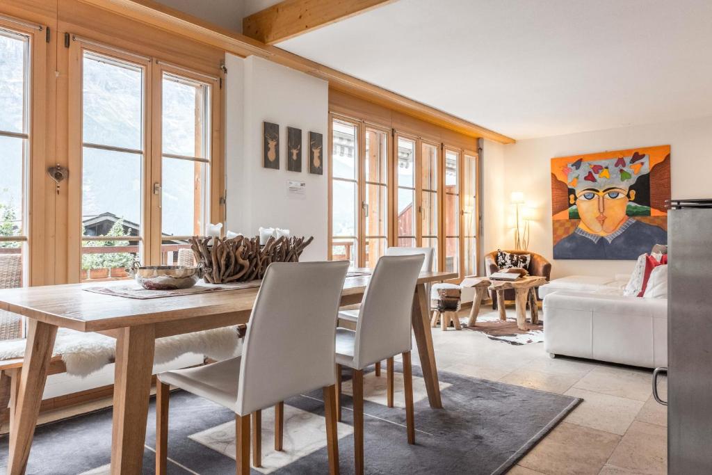 ein Esszimmer mit einem Holztisch und Stühlen in der Unterkunft Apartment Alpin DG - GRIWA RENT AG in Grindelwald