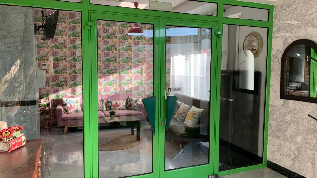 a green glass door in a living room with a couch at Apto. Singular en la Mancha Banco de Inversiones in Argamasilla de Alba