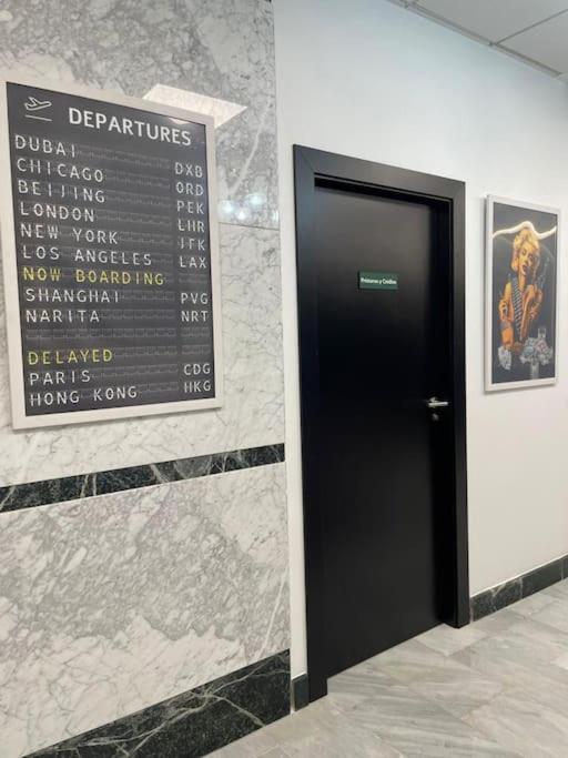 a black door in a wall with a sign at Apto. Singular en la Mancha Banco de Inversiones in Argamasilla de Alba