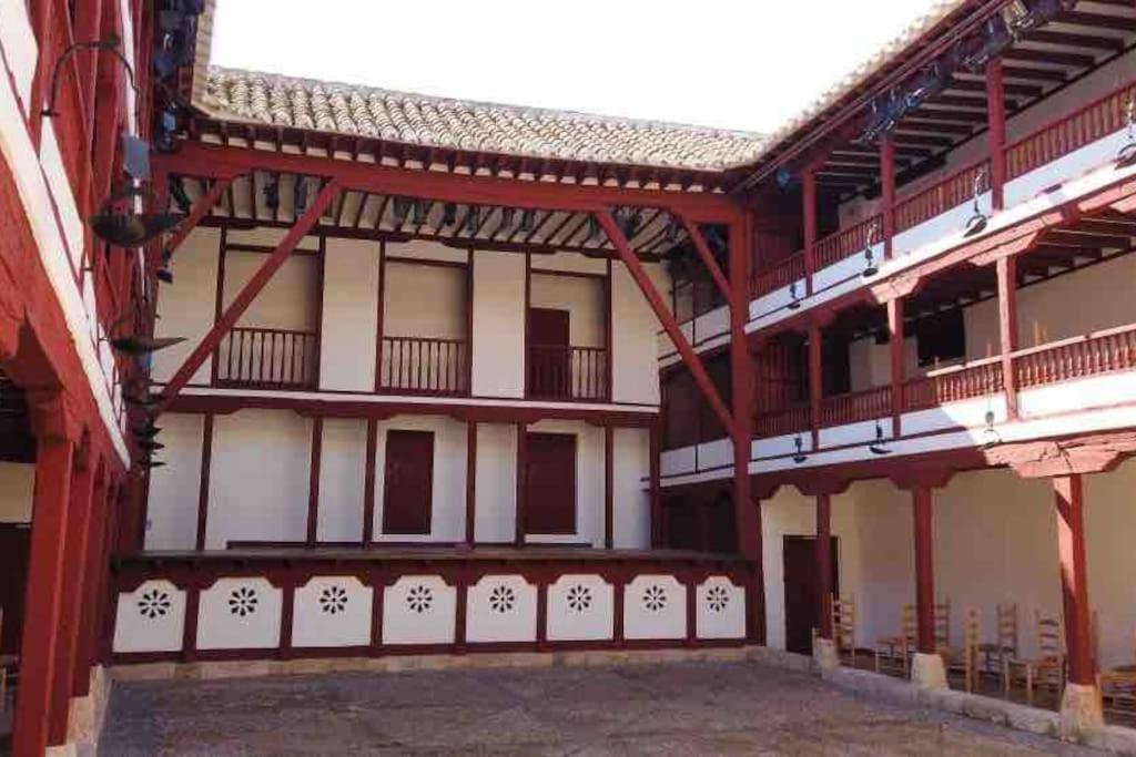 a building with red and white walls and balconies at Apto. Singular en la Mancha Banco de Inversiones in Argamasilla de Alba
