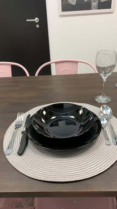 a table with a black plate and fork and a glass at Apto. Singular en la Mancha Banco de Inversiones in Argamasilla de Alba