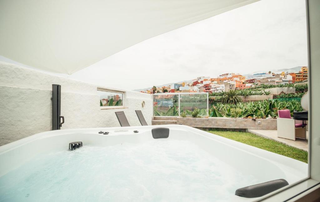 Casa Tulipanes & Spa في سانتا كروث دي تينيريفه: حوض استحمام كبير في غرفة مع نافذة
