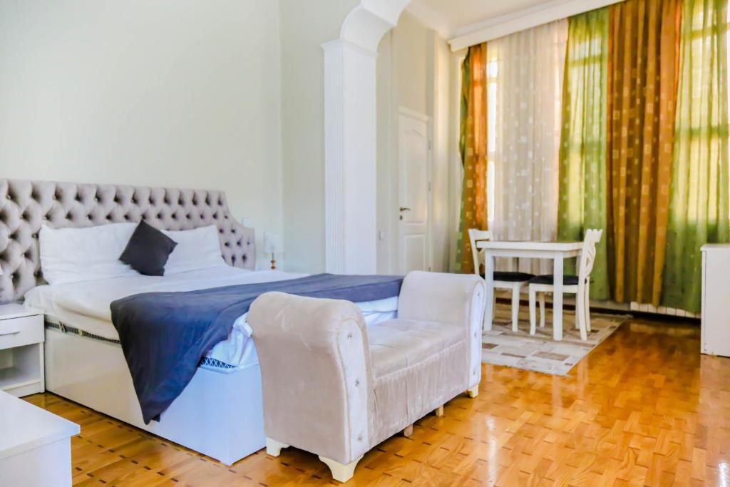 a bedroom with a bed and a chair and a table at WH Hotel & SPA in Baku