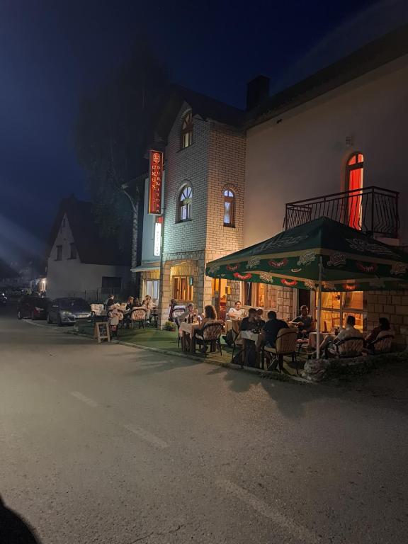 a group of tables and chairs in front of a building at Guesthouse Ukus Durmitora in Žabljak