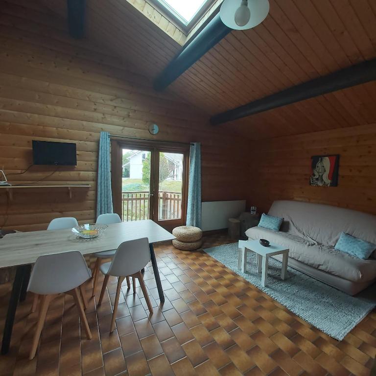 un salon avec une table et un canapé dans l'établissement chalet de la Cercenée, à Gérardmer