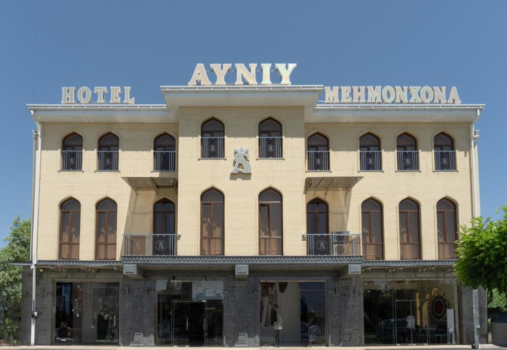 a building with a sign on top of it at AYNIY Hotel in Samarkand