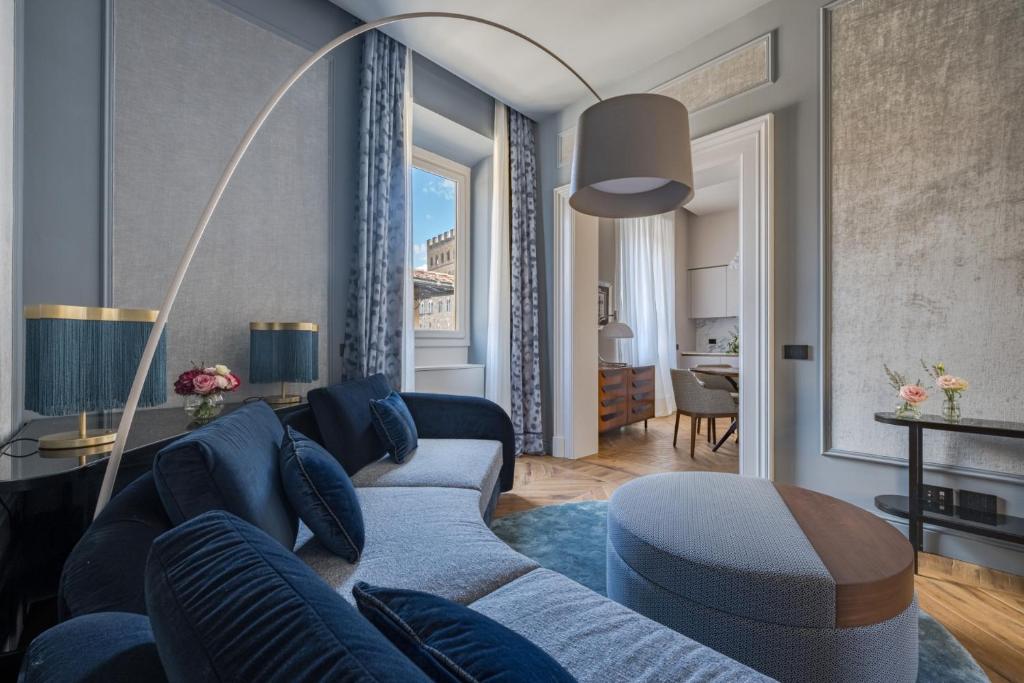 ein Wohnzimmer mit einem blauen Sofa und einem Tisch in der Unterkunft Palazzo Signoria luxury Apartments 2-David in Florenz