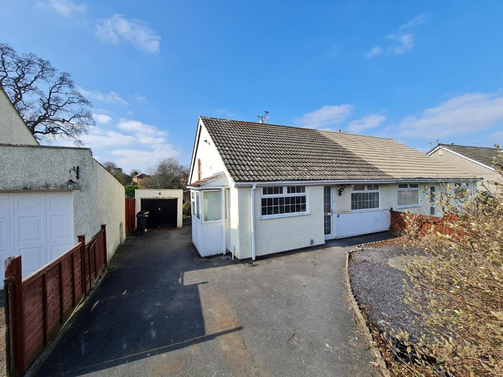 a house with two garage doors and a driveway at 2-Bed House Bungalow in Bristol in Bristol