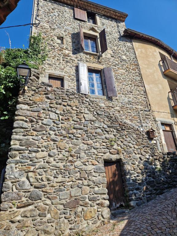 an old stone building with two windows on it at Gîte d'Aigoual in Valleraugue