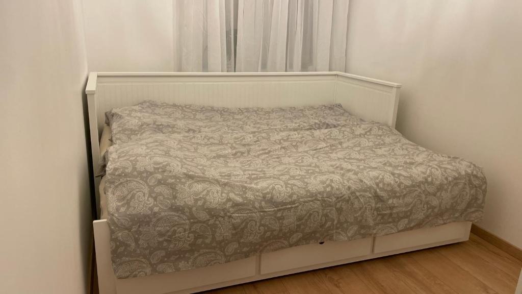 un lit blanc dans une chambre avec une fenêtre dans l'établissement Mini Wind Apartment, à Liepāja