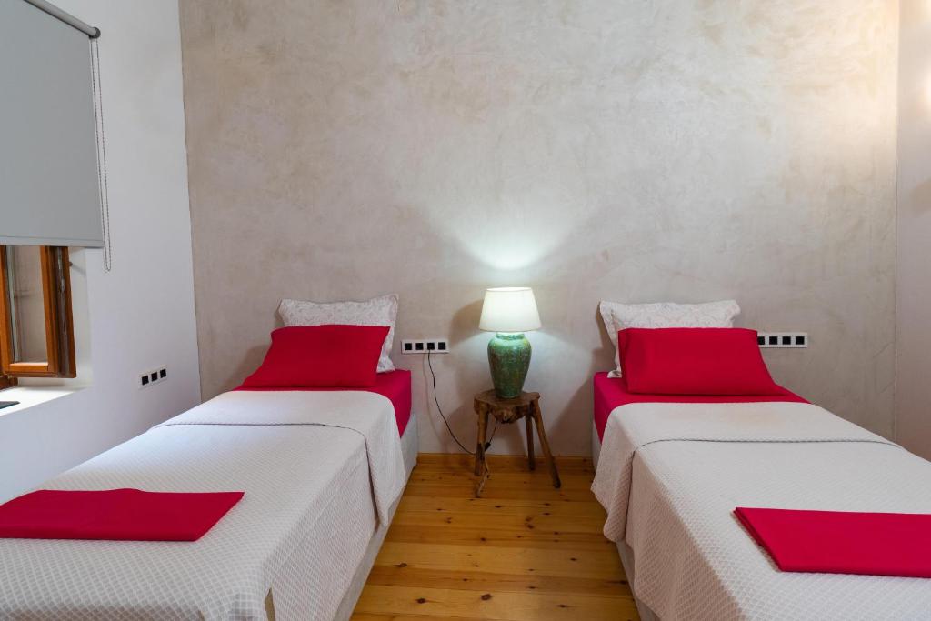 two beds in a room with red pillows at Luminous Luxury Apartment in Chania