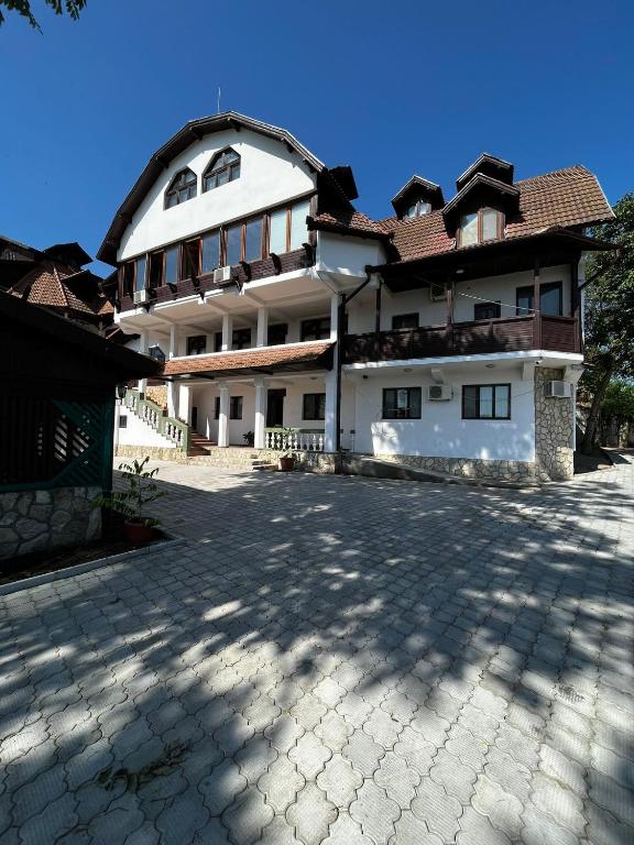a large white building with a roof at La Conac in Nufăru