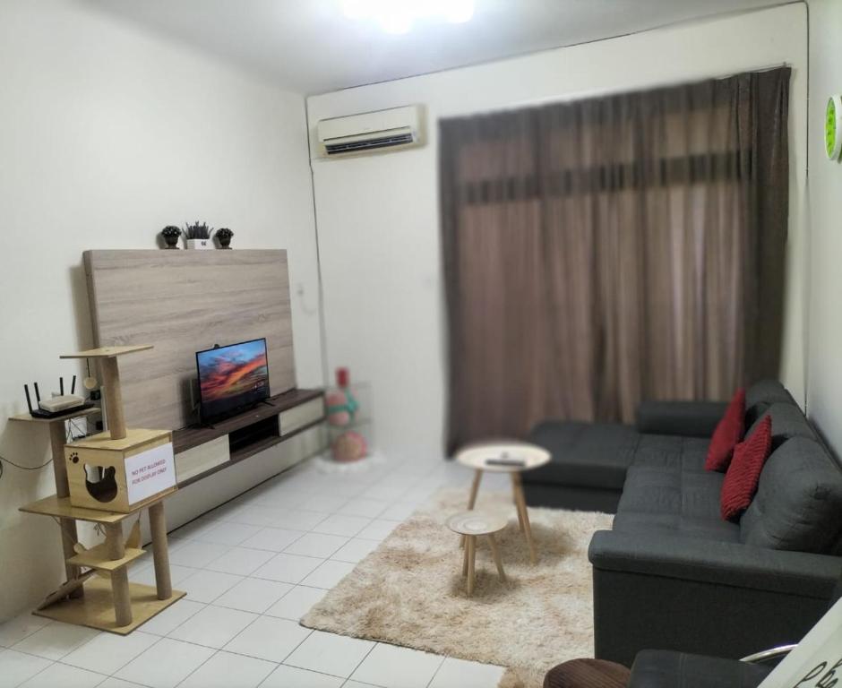 sala de estar con sofá azul y TV en Upper Sanctuary en Kuching