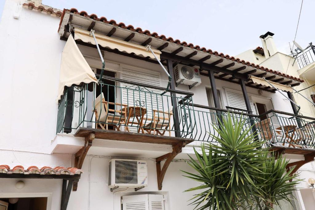 a white building with a balcony with chairs on it at Al Mar 2 in Skiathos