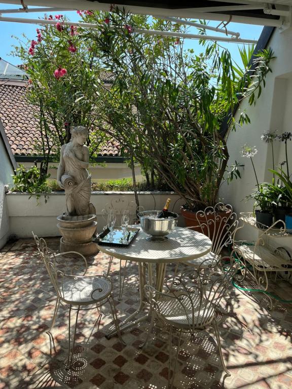 a patio with a table and chairs and a statue at Imperial Terrace suite in Milan