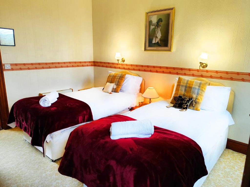 Habitación de hotel con 2 camas con sábanas rojas en The Falls - Value Rooms at Aultnagar Estate, en Lairg